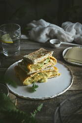 Avocado, Käse, Omelett-Sandwich auf Keramikteller auf Holztisch serviert - ADSF33724