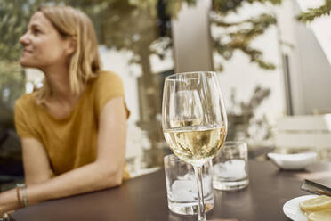 Frau mit Weinglas auf einem Tisch im Restaurant sitzend - SSCF00915