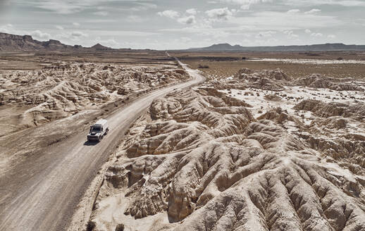 Auto auf einer Wüstenstraße in der Landschaft von Bardenas Reales, Spanien - SSCF00949