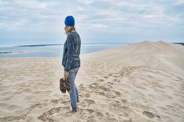 Frau mit Sandale steht auf Sand am Strand - SSCF00964