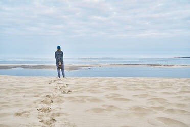 Tourist schaut auf das Meer und steht auf Sand - SSCF00967