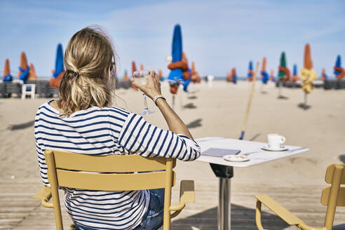 Frau mit Weinglas auf einem Stuhl sitzend im Urlaub - SSCF01005