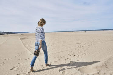 Frau läuft am Strand auf Sand - SSCF01010