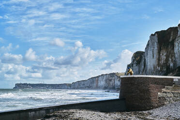 Tourist sitzt auf einem Felsen am Meer - SSCF01036