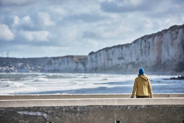 Tourist bewundert das Meer auf der Mauer sitzend im Urlaub - SSCF01038