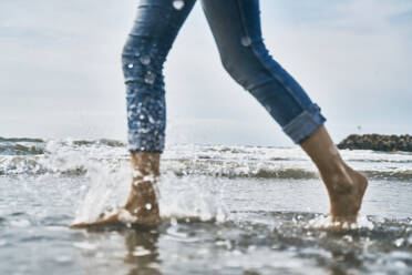 Frau geht am Strand auf dem Wasser - SSCF01063