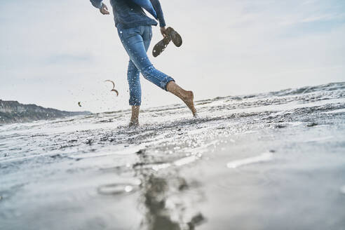 Tourist running in sea at beach - SSCF01064