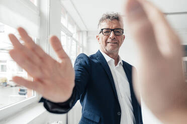 Businessman doing high-five with colleague in office - JOSEF07280