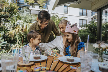 Glückliche Eltern im Gespräch mit Kindern auf einer Geburtstagsfeier im Hinterhof - MFF08571