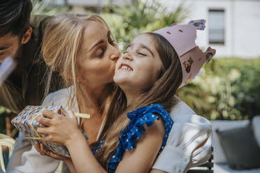 Mutter küsst Tochter mit Geschenk zu ihrem Geburtstag - MFF08574
