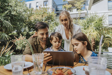 Familie auf Videoanruf über Tablet-Computer im Hinterhof - MFF08579