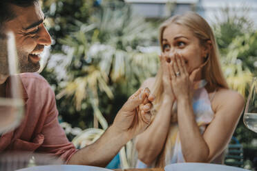 Happy man surprising woman with ring - MFF08618