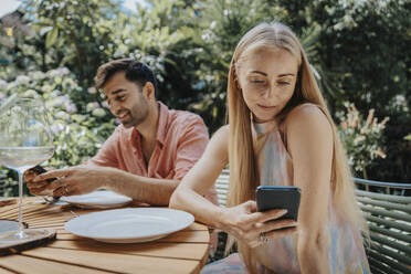 Couple using smart phones on terrace - MFF08620