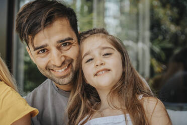 Smiling father and daughter at patio - MFF08644