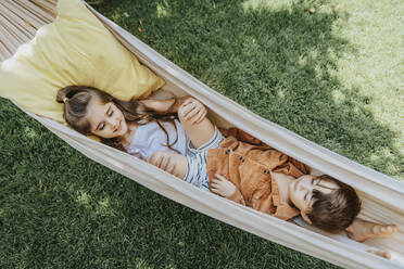 Siblings lying in hammock at back yard - MFF08647