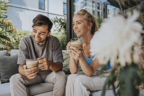 Fröhliches Paar beim gemeinsamen Kaffeetrinken in der Lounge - MFF08653