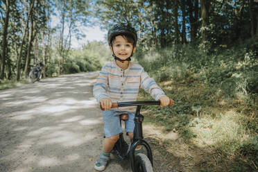 Lächelnder Junge beim Radfahren auf der Straße - MFF08670