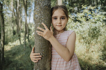 Innocent girl embracing tree in nature - MFF08677