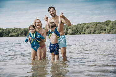 Glückliche Familie, die am Wochenende im See steht - MFF08692