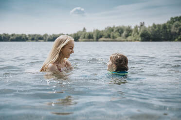 Glückliche Mutter und Tochter beim Schwimmen im See - MFF08701