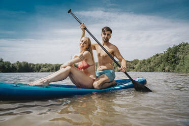 Mann paddelt mit Frau auf einem See - MFF08721