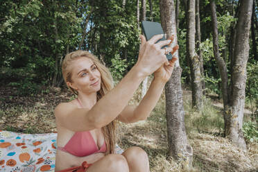 Frau im Bikini nimmt Selfie auf Smartphone - MFF08725