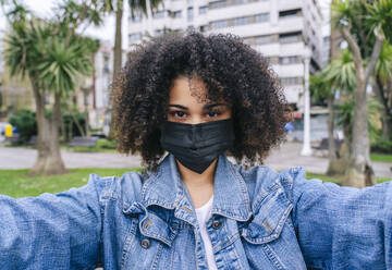 Afro-Frau mit Gesichtsschutzmaske macht Selfie in der Stadt - DGOF02290