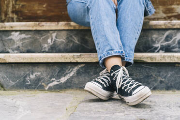 Woman with canvas shoes on footpath - DGOF02306