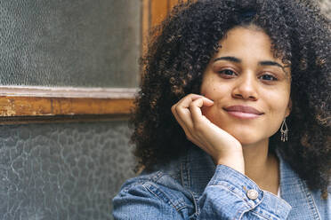 Lächelnde Afro-Frau mit Hand am Kinn - DGOF02309