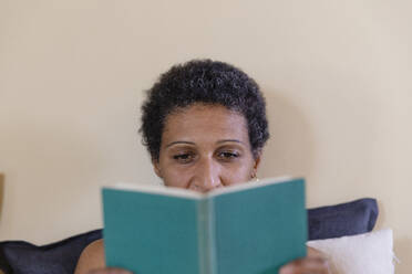 Frau liest ein Buch auf dem Bett im Schlafzimmer - EIF03476