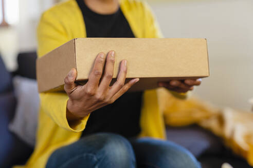 Woman holding cardboard box at home - EIF03507