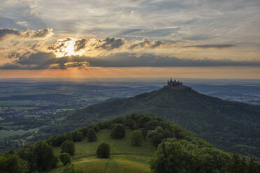 Deutschland, Baden-Württemberg, Hechingen, Blick auf den bewaldeten Hohenzollernberg bei Sonnenuntergang - RUEF03520