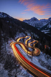 Car light trails stretching along winding road of Maloja Pass at dusk - RUEF03526