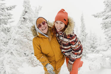 Glückliche Freunde stehen im Winterwald im Urlaub - VBUF00006