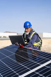 Ingenieur arbeitet an Laptop mit Sonnenkollektoren - DLTSF02742