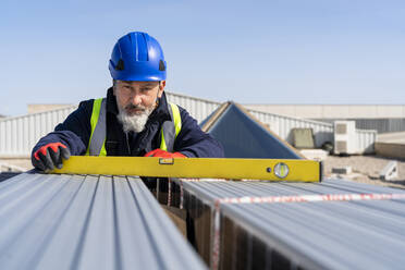 Ingenieur mit Messgerät bei der Arbeit in einem Solarkraftwerk - DLTSF02744