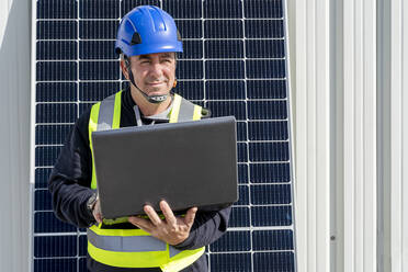 Nachdenklicher Ingenieur mit Laptop im Solarkraftwerk - DLTSF02752