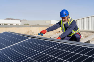 Techniker bei der Installation von Sonnenkollektoren an einem sonnigen Tag - DLTSF02757