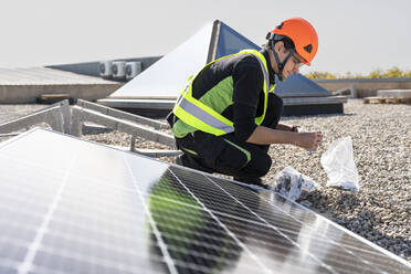 Techniker bei der Montage und Installation von Sonnenkollektoren an einem sonnigen Tag - DLTSF02764