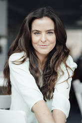 Smiling woman with brown hair in coffee shop - KNSF09375