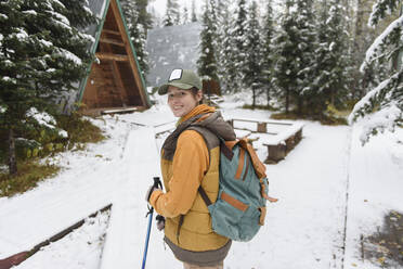 Frau blickt über die Schulter und steht auf Schnee im Winterwald - VBUF00015