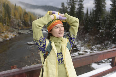 Young woman with head in hands day dreaming on bridge in winter - VBUF00025