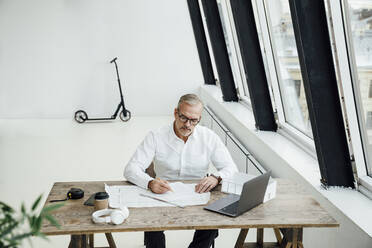 Architekt, der an einem Laptop im Startup-Büro an einem Dokument schreibt - VPIF05470