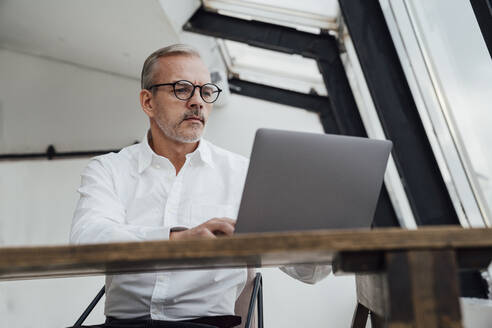 Geschäftsmann arbeitet am Laptop in einem Startup-Büro - VPIF05473