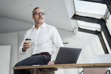 Thoughtful architect with disposable cup at start up office - VPIF05481