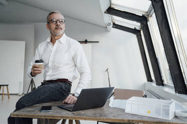 Nachdenklicher Architekt mit Einwegbecher im Büro - VPIF05482