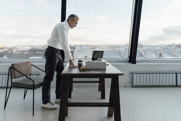 Geschäftsmann arbeitet am Laptop am Schreibtisch im Büro - VPIF05484