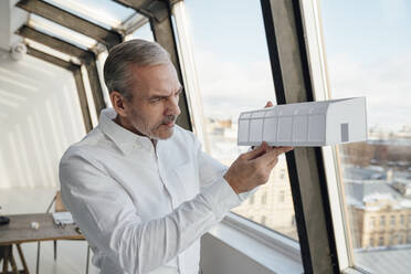 Geschäftsmann beim Analysieren eines Architekturmodells im Büro - VPIF05486