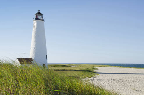 Great Point Lighthouse am bewachsenen Strand gegen den klaren Himmel - TETF00041