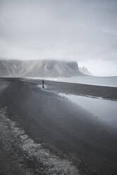 Man walking on black sand beach in Kirkjubµjarklaustur, Iceland - TETF00058